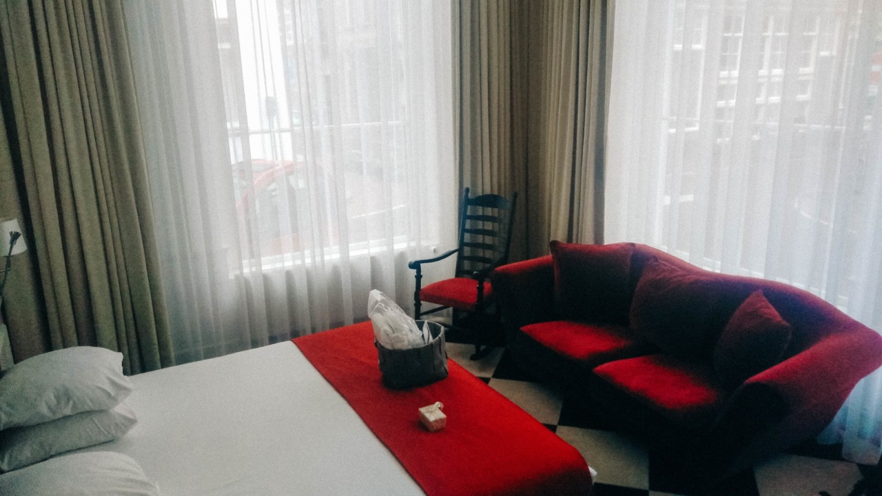 Un divan rouge offre un espace détente dans la suite de l'hôtel Mercure à Amsterdam